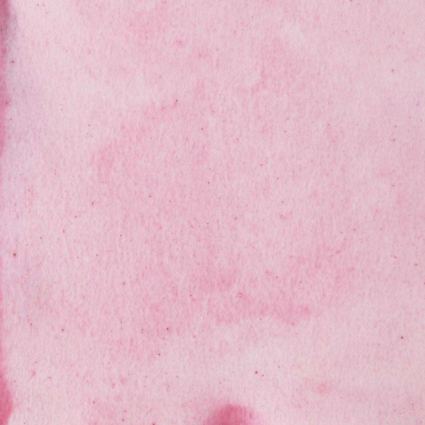 The image is a close-up of a pinkish-red fabric or surface, with a slightly wrinkled texture. There are no discernible objects or actions depicted in the image.