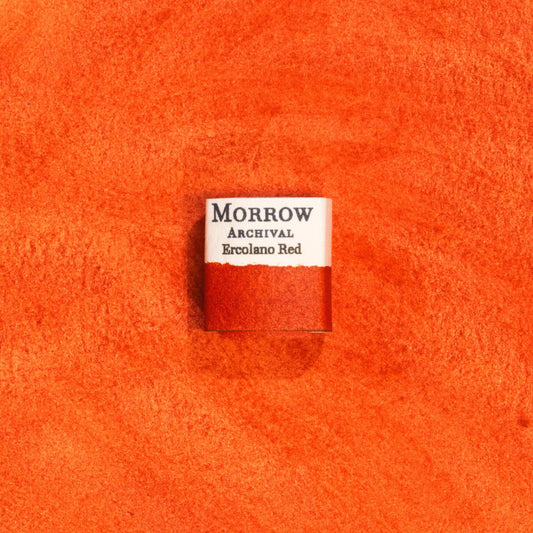 Handmade Ercolano Red natural watercolor paint half pan shown on a textured watercolor painting. Made from pure single-pigment natural red ochre, this warm, earthy red offers rich coverage, soft granulation, and excellent transparency, perfect for botanical illustration, historical painting, and fine art. A beautiful eco-friendly gift for watercolor artists and collectors seeking small-batch, archival-quality, all-natural handmade pigments rooted in ancient traditions.