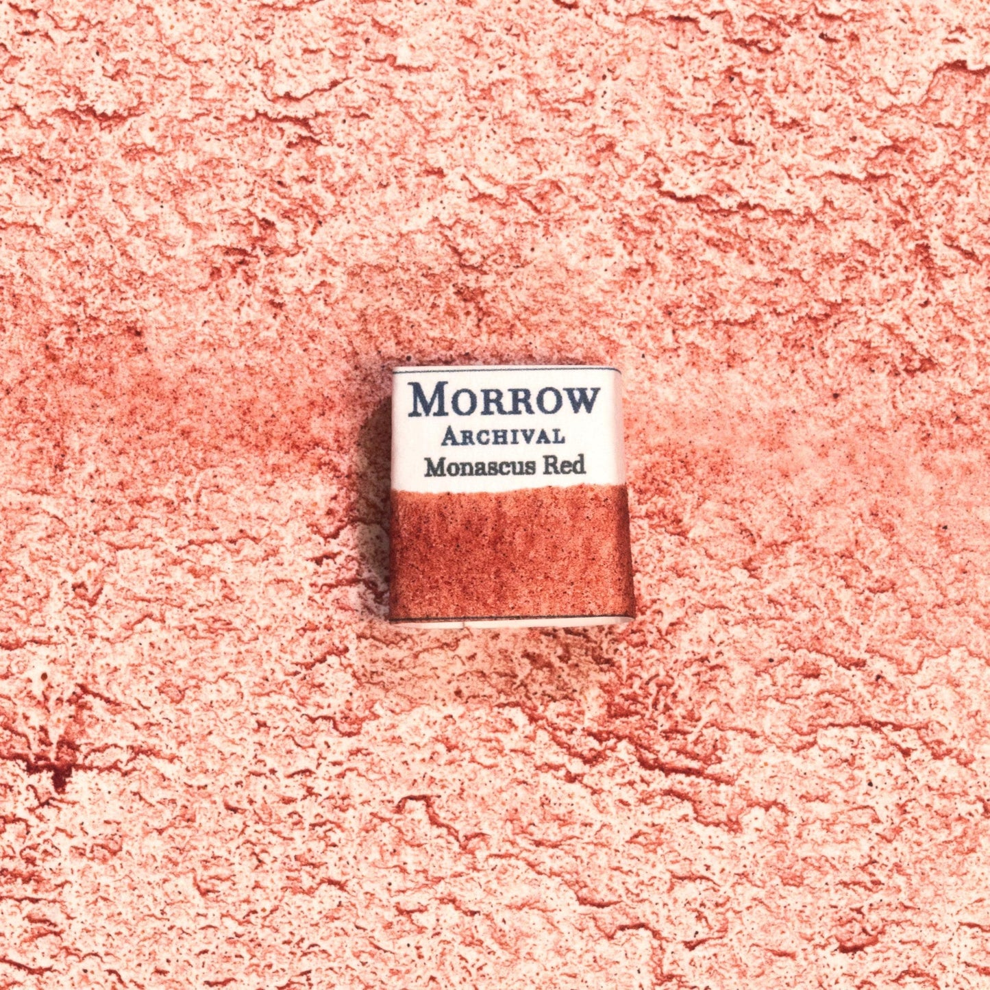 Handmade Monascus Red natural watercolor paint half pan shown on a textured watercolor painting. Crafted from pure single-pigment Monascus yeast, this rich, vibrant red offers deep, organic color with beautiful transparency, perfect for botanical art, historical painting, and fine illustration. An exceptional eco-friendly gift for watercolor artists and collectors seeking small-batch, archival-quality, all-natural handmade pigments rooted in ancient dye traditions.