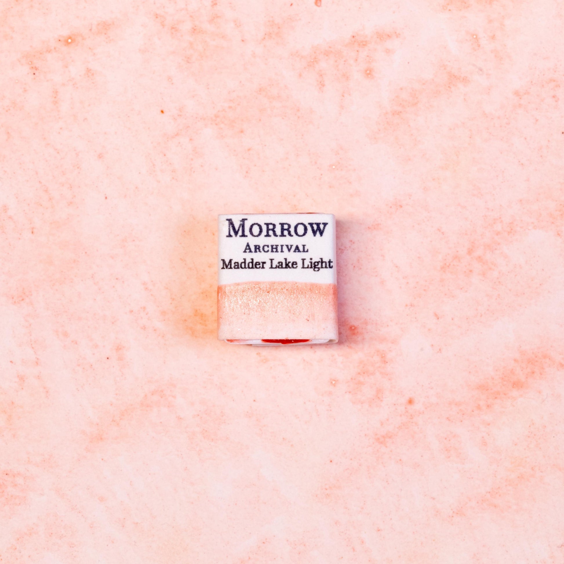 Watercolor painting with a hand made archival watercolor pan with elegant and vibrant label in watercolor paper in soft rose Madder Lake Light, a delicate version of madder root pigment (Rubia tinctorum), historically used for fine glazes and portrait work. Handcrafted with honey and gum arabic. Transparent and lightfast, ideal for botanical illustration, soft pink tones, and traditional European palettes.