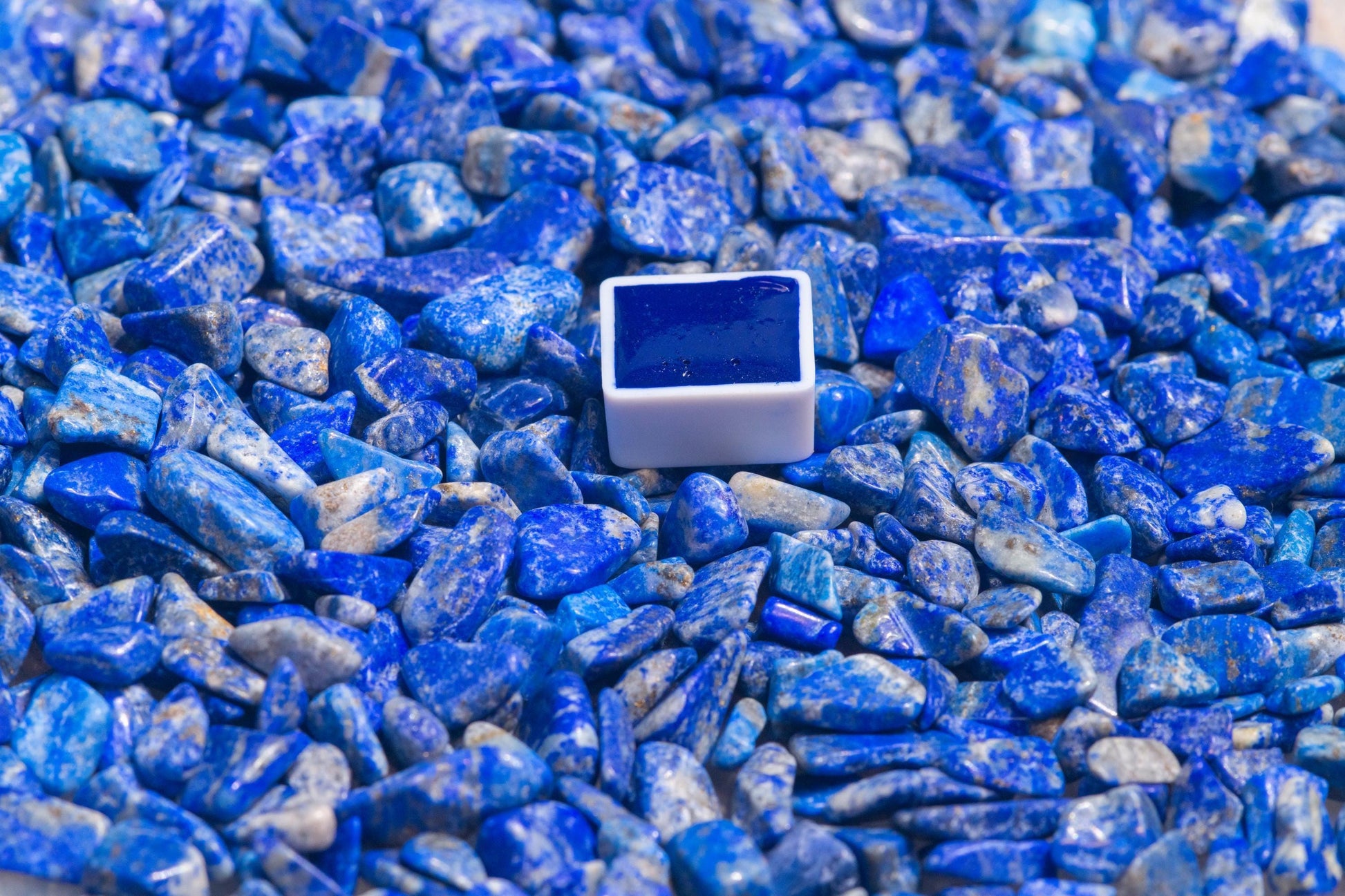 Fra Angelico Blue watercolor half pan resting on a vibrant, raw lapis lazuli stone‚Äîthe legendary source of this brilliant ultramarine pigment. Handcrafted from genuine Afghan lapis, this artist-grade watercolor captures the intense, luminous blue prized by Renaissance masters. Ideal for fine art, iconography, and historical palettes. For Fra Angelico Blue watercolor, natural ultramarine pigment, lapis lazuli paint, and premium handmade art supplies.