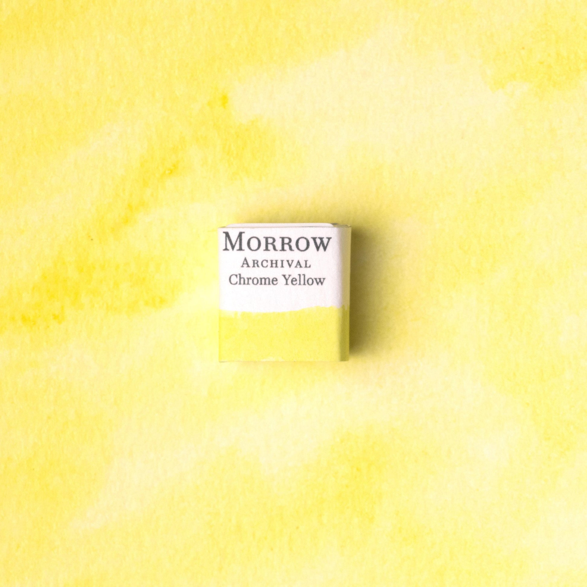 Handmade Chrome Zinc Yellow natural watercolor paint half pan resting on a textured watercolor painting. Made from pure single-pigment zinc chromate, this bright, opaque yellow offers excellent coverage, vibrant tone, and historic authenticity‚Äîideal for botanical illustration, vintage palette recreations, and fine art painting. A striking eco-friendly gift for watercolor artists and collectors seeking small-batch, archival-quality, all-natural handmade pigments with industrial-era roots.