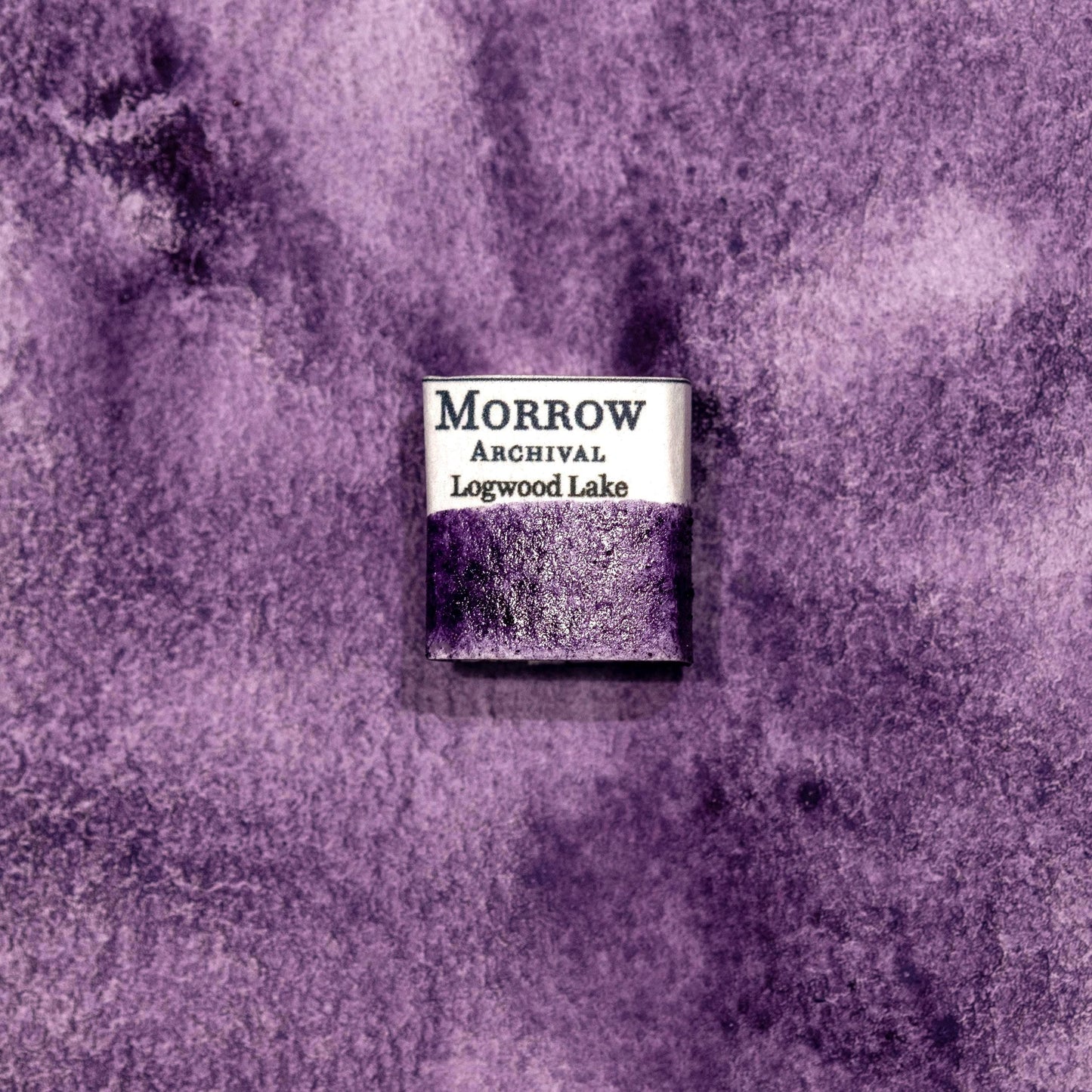Watercolor painting with a handmade archival watercolor pan with elegant and vibrant label in watercolor paper in Logwood Lake Purple, a deep, velvety purple pigment extracted from the heartwood of the Haematoxylum campechianum tree, historically used in colonial-era dyeing and natural ink making. Handcrafted with honey and gum arabic. Transparent and moderately lightfast, ideal for historical botanical work, natural dye palettes, and expressive shadows or glazes.