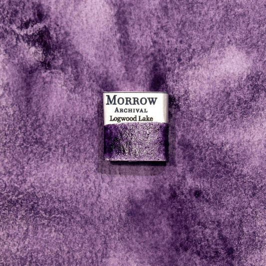 Watercolor painting with a handmade archival watercolor pan with elegant and vibrant label in watercolor paper in Logwood Lake Purple, a deep, velvety purple pigment extracted from the heartwood of the Haematoxylum campechianum tree, historically used in colonial-era dyeing and natural ink making. Handcrafted with honey and gum arabic. Transparent and moderately lightfast, ideal for historical botanical work, natural dye palettes, and expressive shadows or glazes.