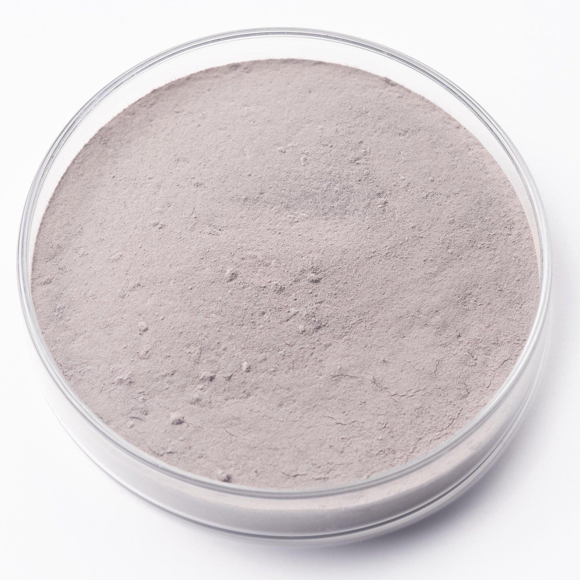 A clear glass container filled with a light brown substance, possibly a powdered material or a sample.