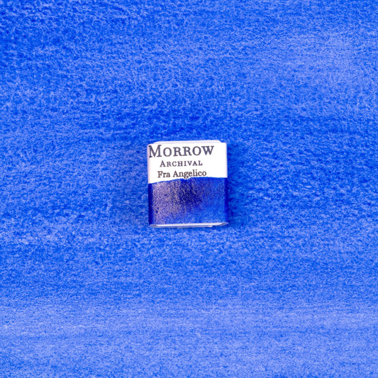 Close-up image of a half pan of Fra Angelico Blue handmade watercolor paint, showing a luminous, sky-toned blue with subtle granulation and a soft matte surface. The pan sits on a neutral or textured background, emphasizing the pigment‚Äôs mineral origin and artisanal craftsmanship. Ideal for artists seeking a historic, radiant blue inspired by Renaissance frescoes and sacred art.