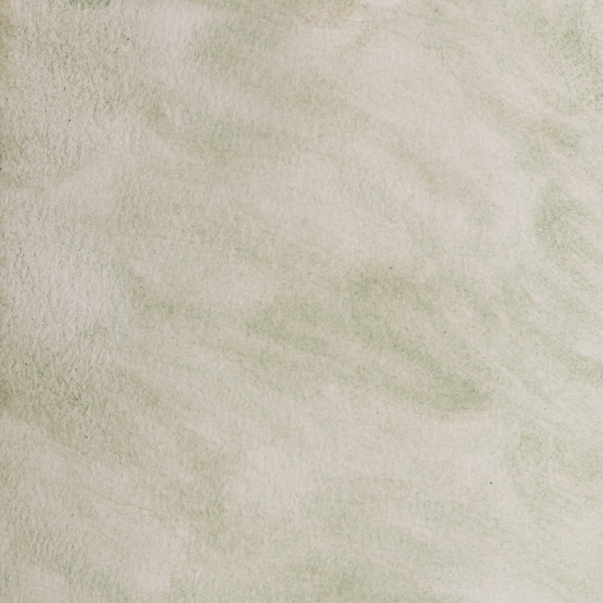 The image is a close-up of a textured surface, possibly a piece of paper or fabric, with a light green or pale green color. The surface appears to be slightly wrinkled and has a textured or rough appearance.