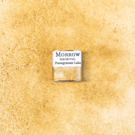 Close-up image of a half pan of Pomegranate Yellow Lake handmade watercolor paint, showing a warm, golden-yellow hue with soft transparency and smooth surface. The pan is set on a neutral background, highlighting the pigment‚Äôs botanical origin and traditional craftsmanship. Ideal for artists seeking a natural, earthy yellow with historical and cultural depth.