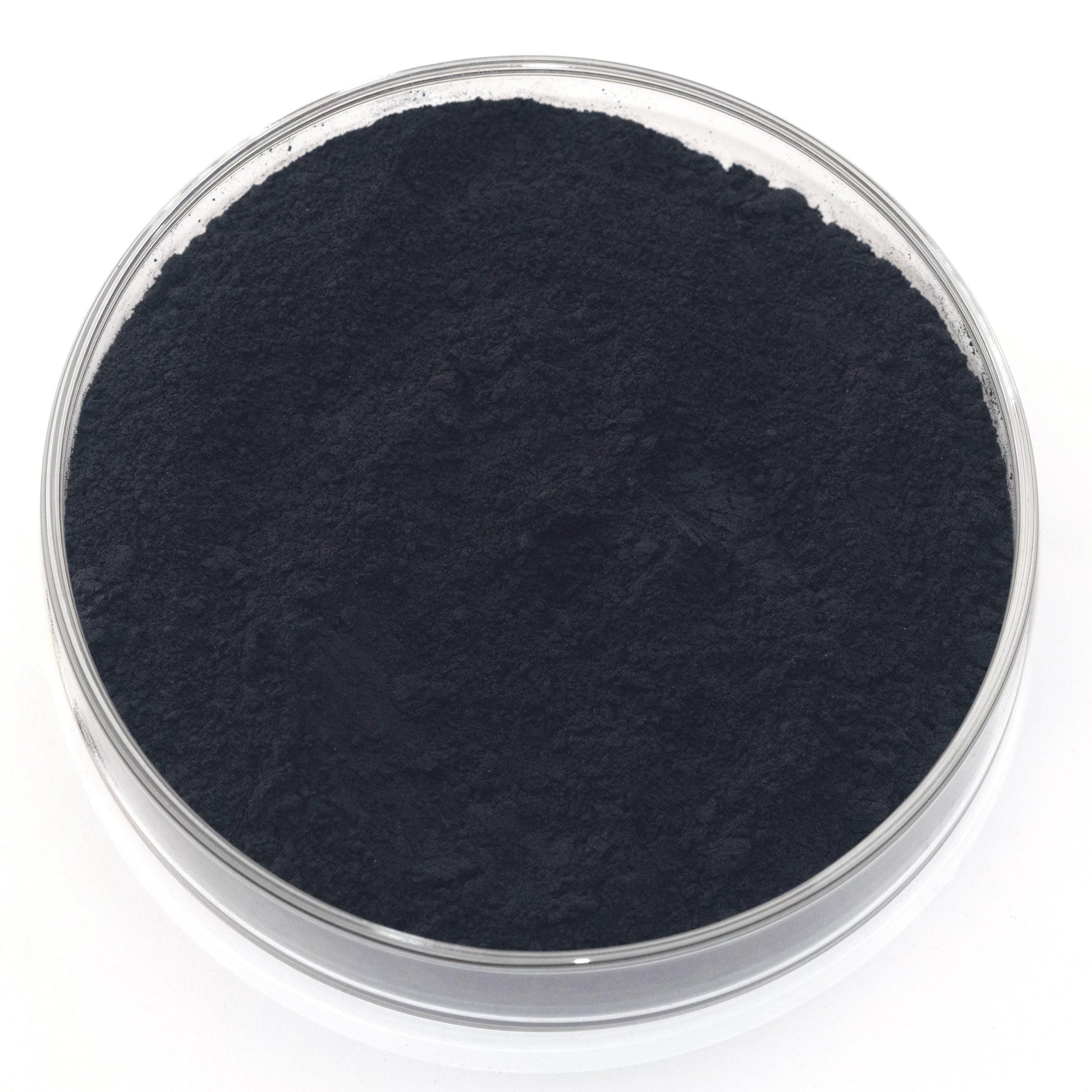 A glass container filled with a dark, powdery substance, possibly a type of carbonate or carbonate compound.