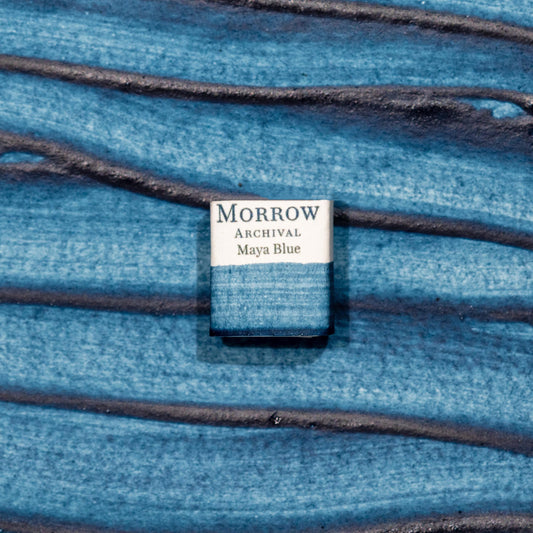 Watercolor painting with a handmade archival watercolor pan with elegant and vibrant label in watercolor paper in True Maya Blue, an enduring turquoise pigment made by hand-mixing fermented Indigofera suffruticosa with palygorskite clay, replicating the sacred and highly stable color used by the ancient Maya. Handcrafted with honey and gum arabic. Semi-transparent and exceptionally lightfast, ideal for historical reconstructions, Mesoamerican palettes, and symbolic sky or water elements.