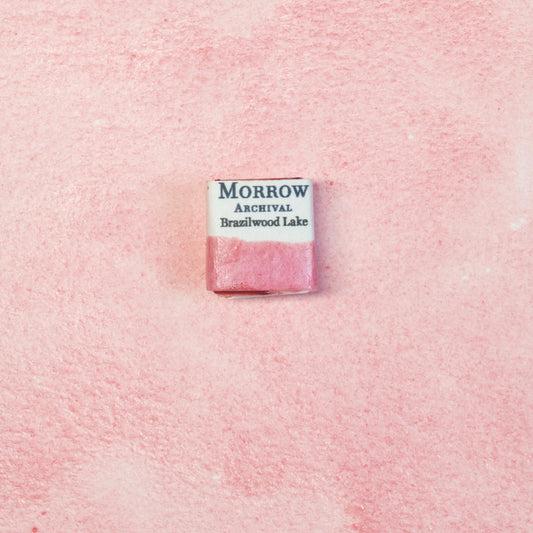 Close-up image of a half pan of Brazilwood Lake Pink handmade watercolor paint, showing a warm, ros√©-pink hue with a soft, translucent finish. The pan sits on a neutral background, highlighting its botanical origin and traditional craftsmanship. Ideal for artists seeking a natural, historical pink with elegance and floral charm.