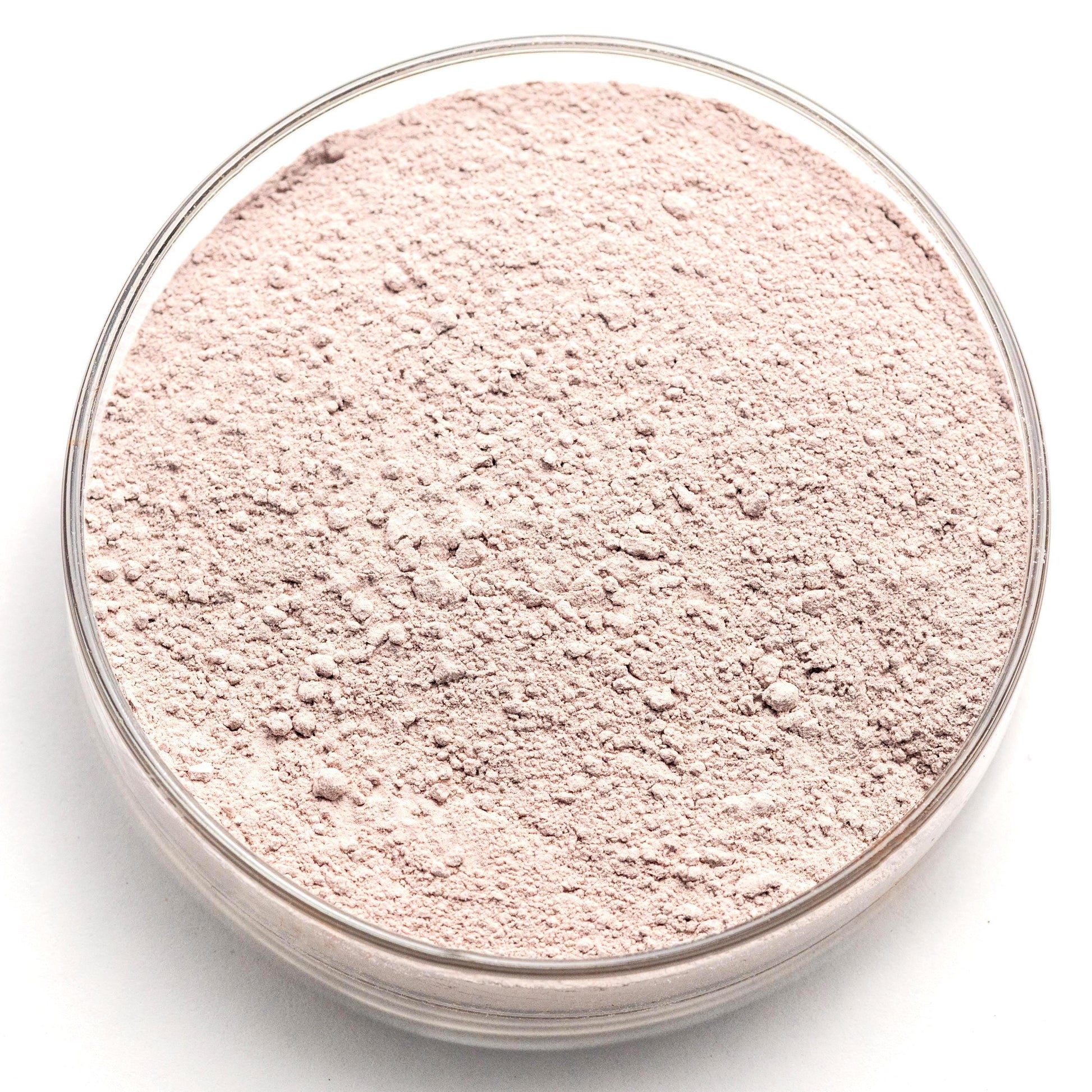 A glass bowl filled with a light pink, powdery substance, possibly a type of flour or seasoning.