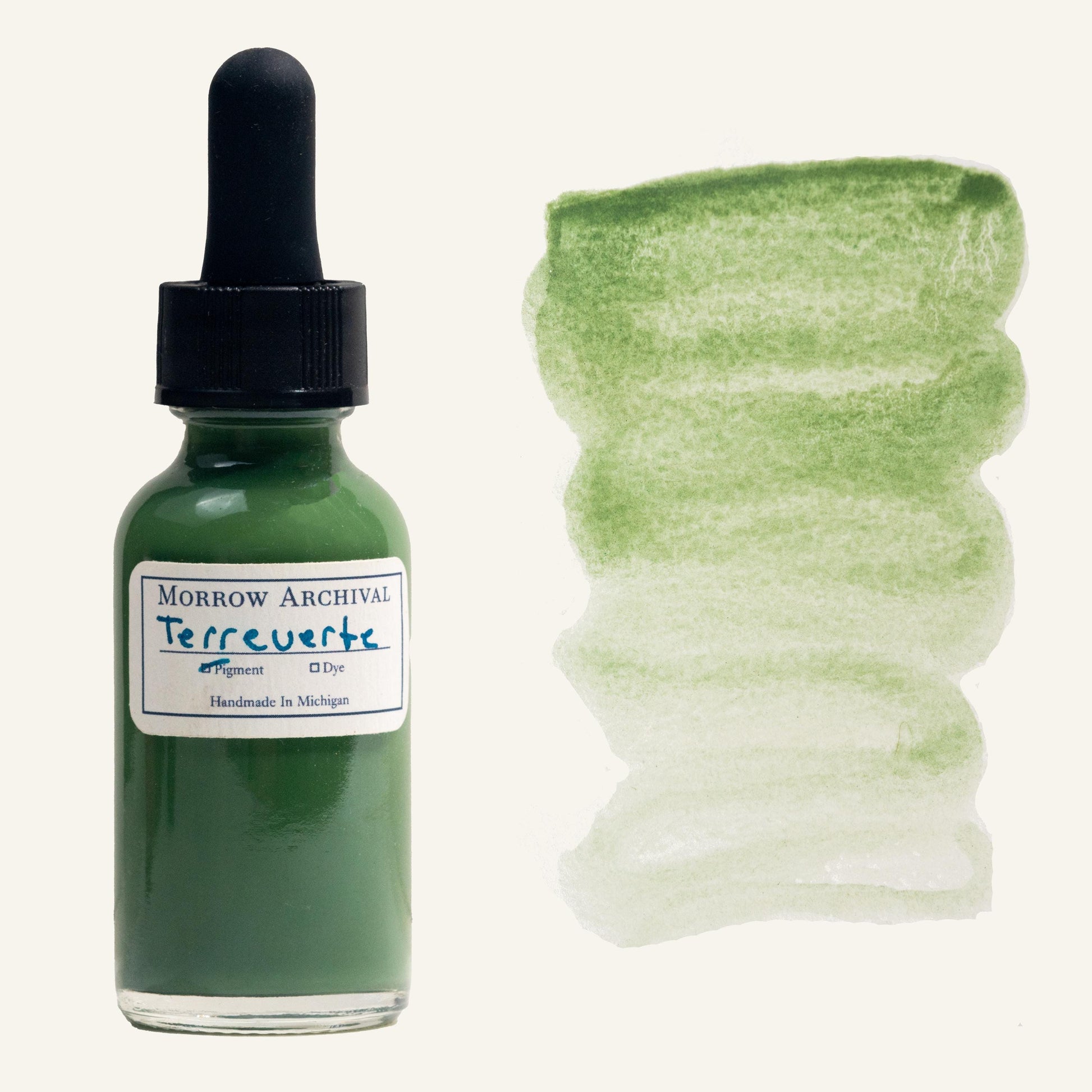 Historical watercolor ink made from natural Terre Verte green earth pigment, bottled in a clear glass dropper bottle with an archival watercolor paper label and hand-painted swatch. This muted, earthy green ink flows smoothly and reveals a soft gradient from cool olive to pale sage. Traditionally used in Renaissance underpaintings and iconography, this archival-quality ink is perfect for historical art, calligraphy, botanical work, and natural pigment collections.