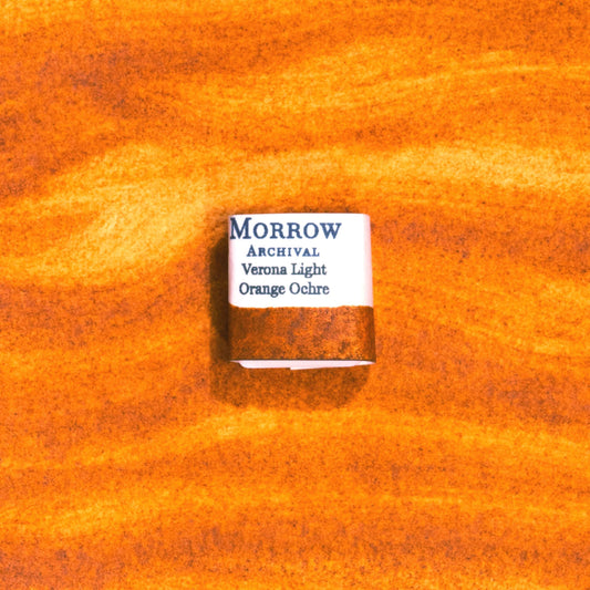Handmade Verona Orange Ochre natural watercolor paint half pan displayed on a textured watercolor painting. Crafted from pure single-pigment natural earth sourced near Verona, Italy, this warm, earthy orange offers soft granulation and excellent transparency, perfect for botanical illustration, landscape painting, and historical fine art. A beautiful eco-friendly gift for watercolor artists and collectors seeking small-batch, archival-quality, all-natural handmade pigments.