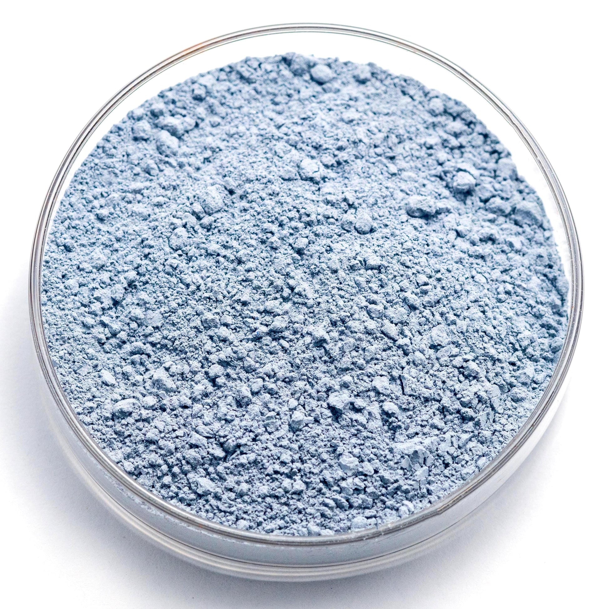 A glass container filled with a blue-gray powder substance, possibly a chemical or industrial ingredient.