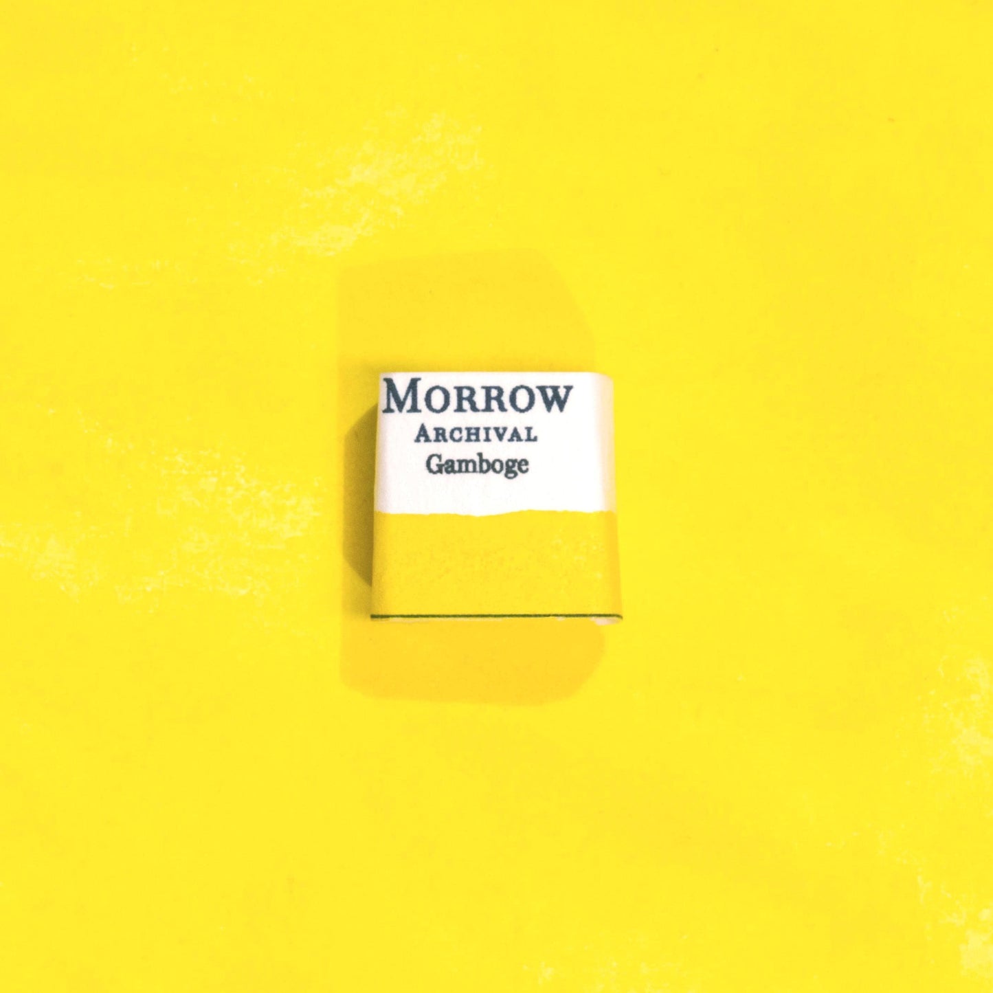 Handmade True Gamboge natural watercolor paint half pan shown on a textured watercolor painting. Made from pure single-pigment gamboge tree resin, this vibrant golden yellow offers rich transparency and smooth flow, ideal for botanical art, historical painting, and fine art illustration. A rare and beautiful eco-friendly gift for watercolor artists and collectors seeking small-batch, archival-quality, all-natural handmade pigments rooted in centuries of artistic tradition.