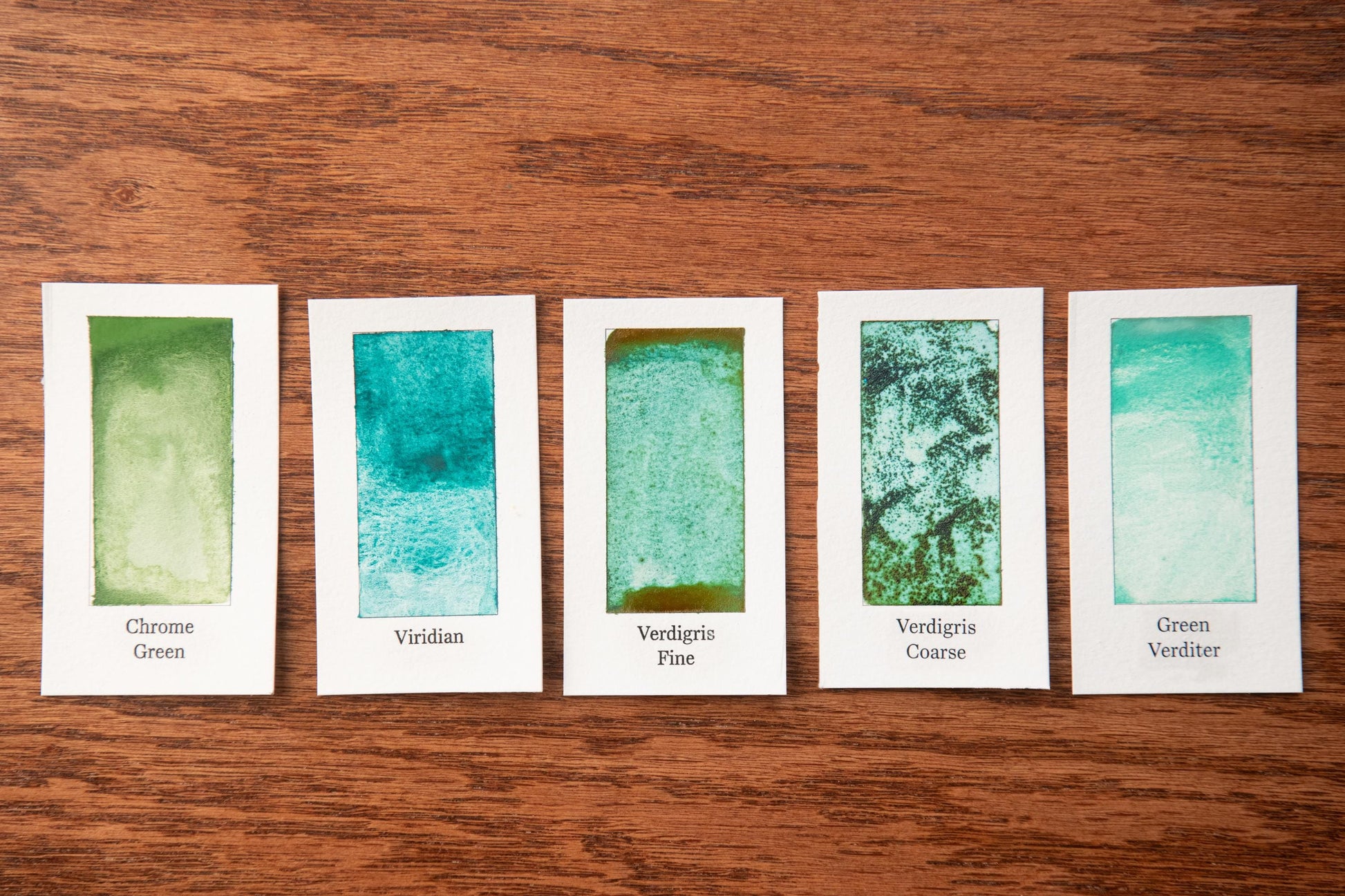 five cards with different shades of green paint, each labeled with a different type of paint stroke.