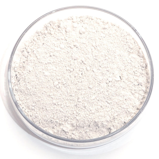 A glass bowl filled with a white powdery substance, possibly flour or cornstarch, sits on a white background.