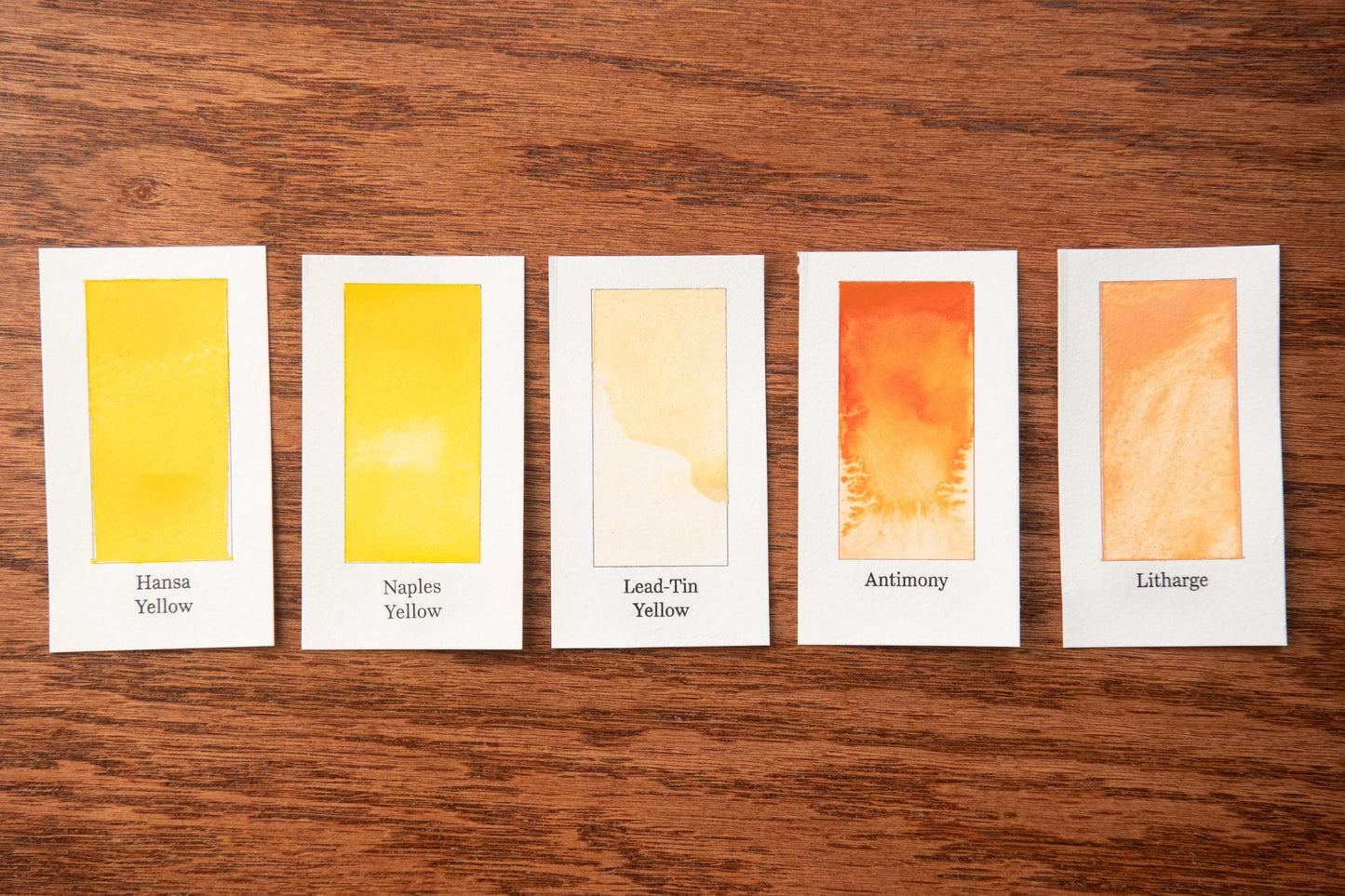 five different shades of yellow paint, each with a label indicating the name of the color.