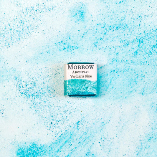 Close-up image of a half pan of Verdigris handmade watercolor paint, featuring a soft, blue-green hue with delicate granulation and a translucent finish. The pan rests on a neutral background, highlighting the pigment‚Äôs historic character and artisanal craftsmanship. Ideal for artists seeking a luminous, antique green with classical and botanical appeal.