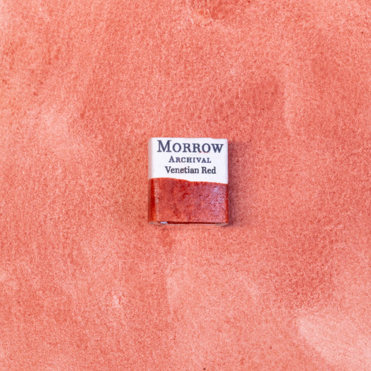 Close-up image of a half pan of Venetian Red handmade watercolor paint, displaying a deep, warm red with earthy undertones and a smooth matte finish. The richly pigmented paint is set against a neutral background, highlighting its natural mineral origin and artisanal craftsmanship. Ideal for artists seeking traditional, non-toxic, earth-based watercolors with historic character.