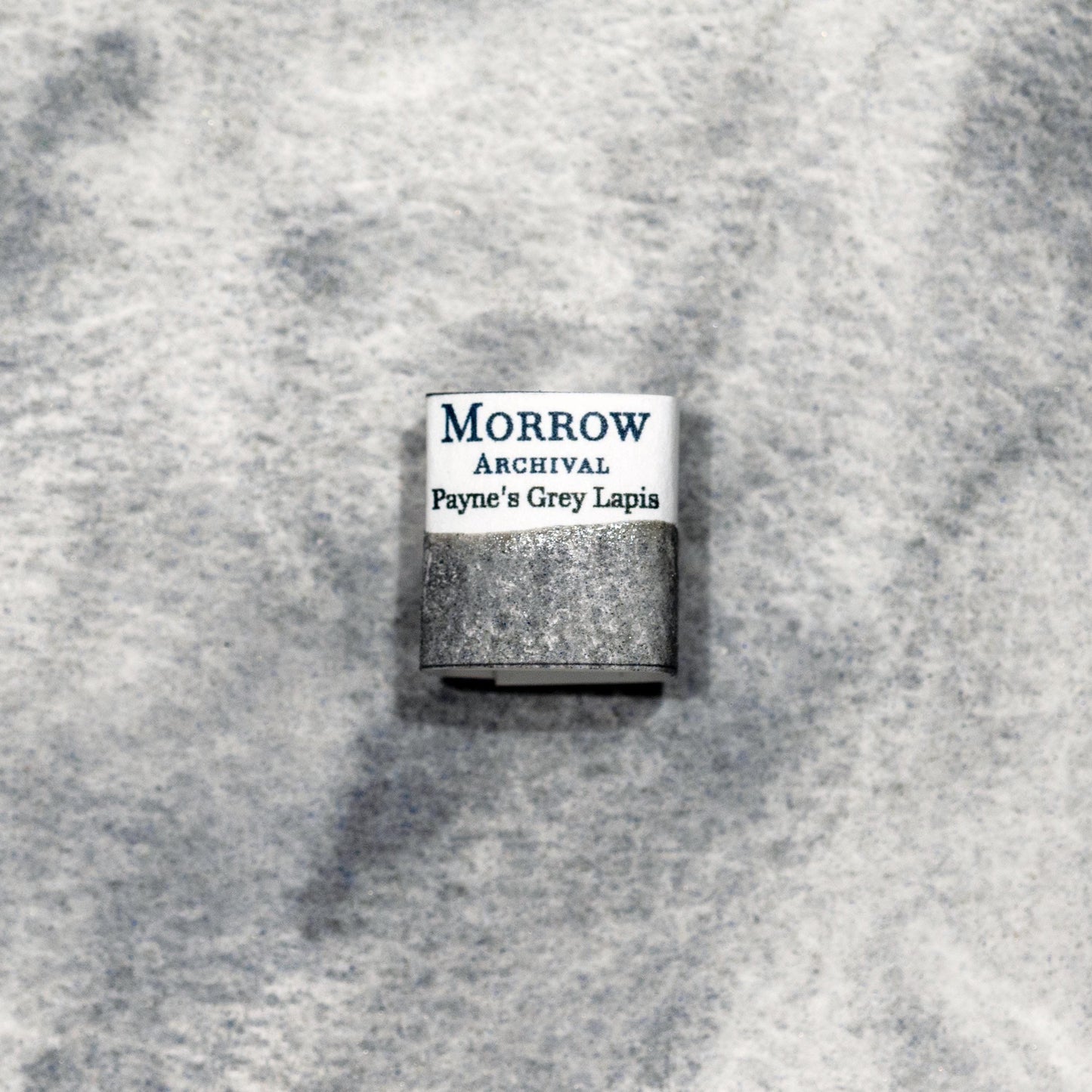 Watercolor painting with a handmade archival watercolor pan with elegant and vibrant label in watercolor paper in Payne‚Äôs Grey (Natural Lapis), a moody, atmospheric grey created from deep grey lapis lazuli stone, blending the mystery of ultramarine with natural mineral depth. Handcrafted with honey and gum arabic. Semi-transparent and lightfast, ideal for shadow work, stormy skies, and classical grisaille techniques.