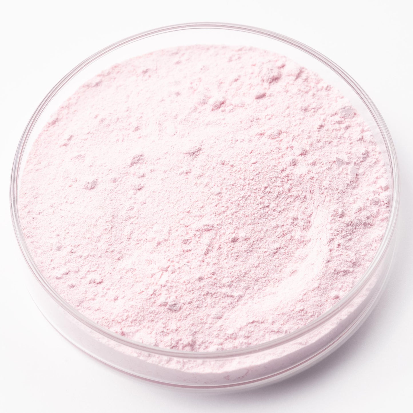 A clear glass container filled with a pink powder substance.