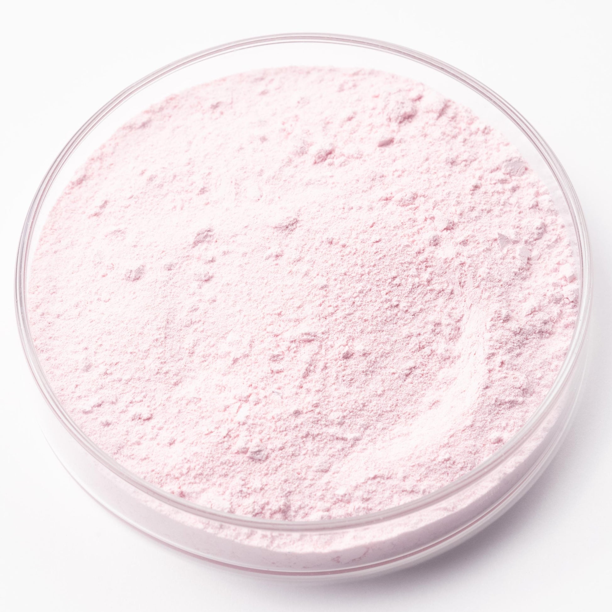 A clear glass container filled with a pink powder substance.