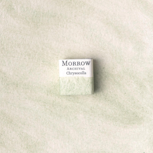 Handmade Chrysocolla natural watercolor paint half pan shown on a textured watercolor painting. Crafted from pure single-pigment chrysocolla stone, this vivid turquoise-blue offers bold granulation and unique mineral texture‚Äîperfect for expressive landscapes, abstract art, and historical color studies. A rare eco-friendly gift for watercolor artists and collectors seeking small-batch, archival-quality, all-natural handmade pigments sourced from natural copper-rich stone.