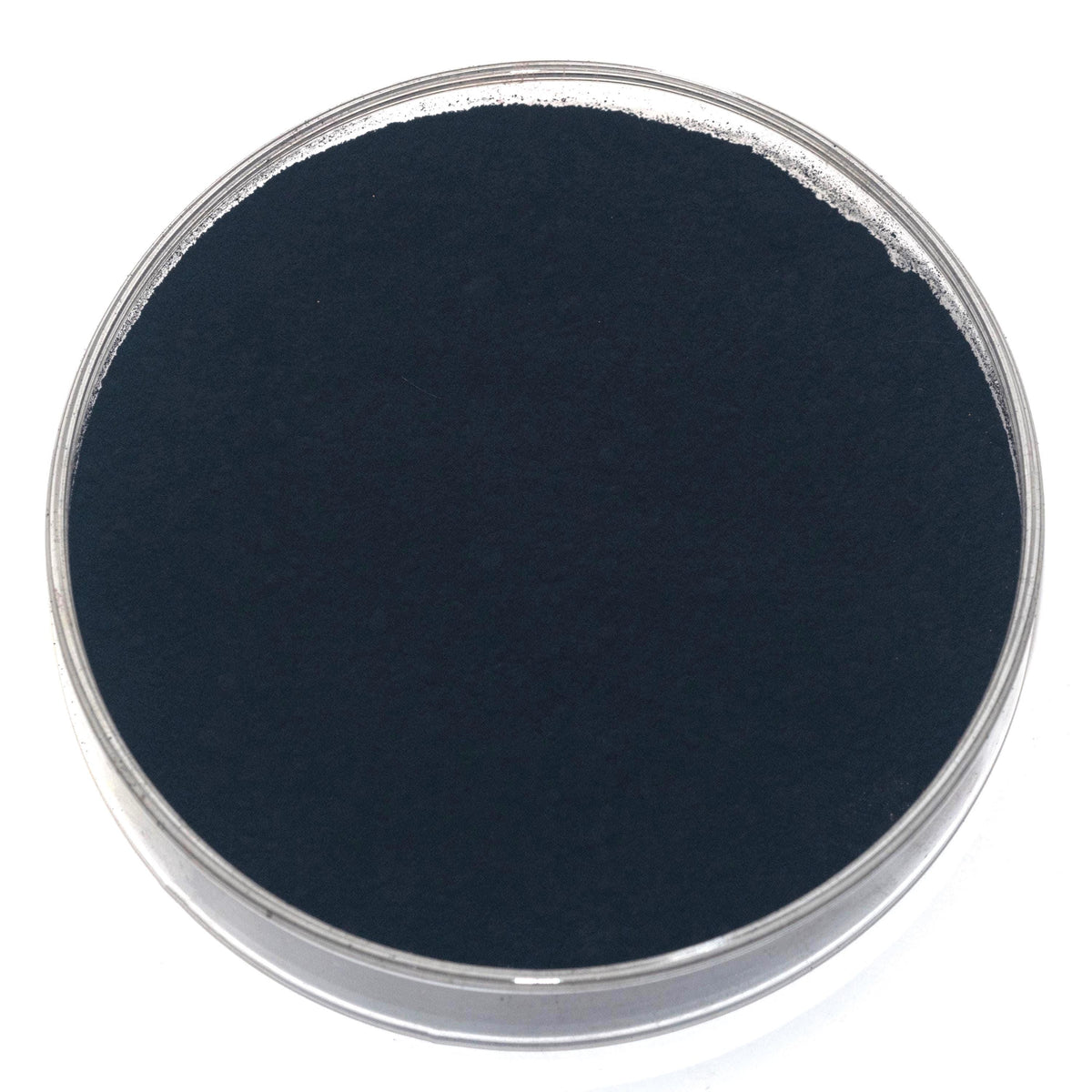 Lamp Black pigment, a fine deep black powder made from soot collected from burning oil, shown in a glass dish.